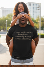 Man wearing a black t-shirt with text, being piggybacked by a woman outdoors.